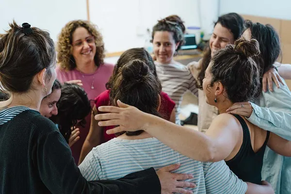 נשים מתחבקות במעגל סביב יולדת במפגש מעגל לידה
